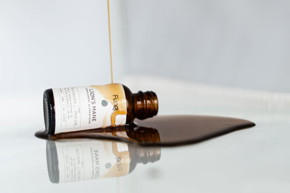 Relaxation Mentale pour le Bien-être | LION MANE bouteille d'extrait liquide en verre sur une surface réfléchissante.